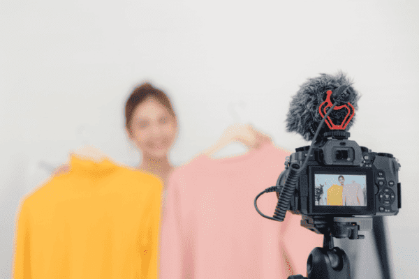 A camera set up in front of mannequins with shirts, promoting influencer marketing tips.