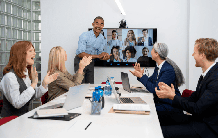 Group of people in a hybrid meeting setup discussing meeting strategies tips