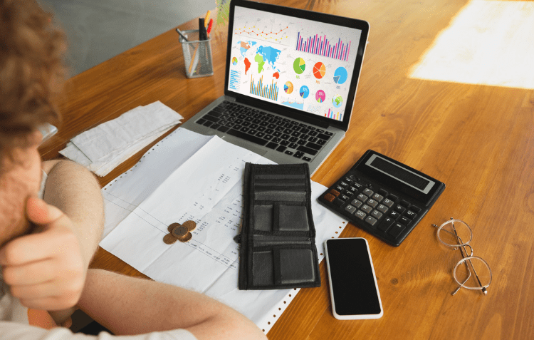 Project Cost Management Software displayed on an open laptop with financial graphs