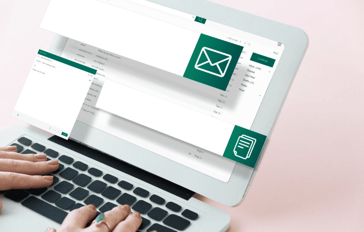 Hands typing on a laptop displaying an email application for email marketing strategies