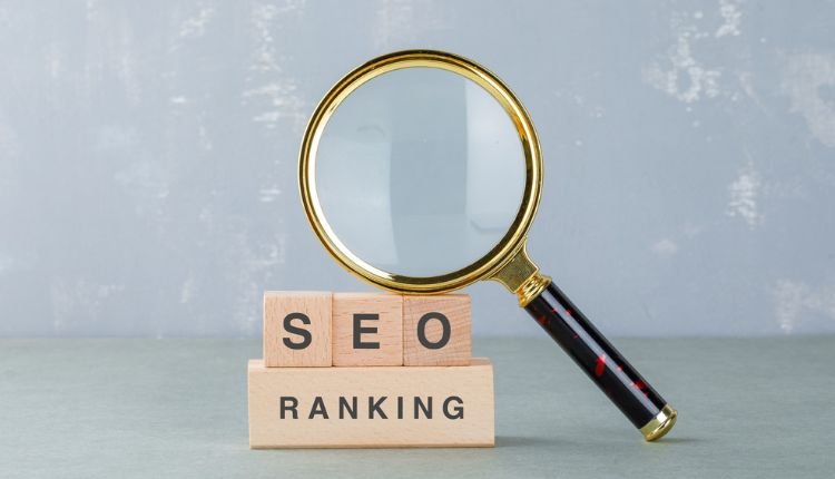 SEO ranking concept with wooden blocks and a magnifying glass.