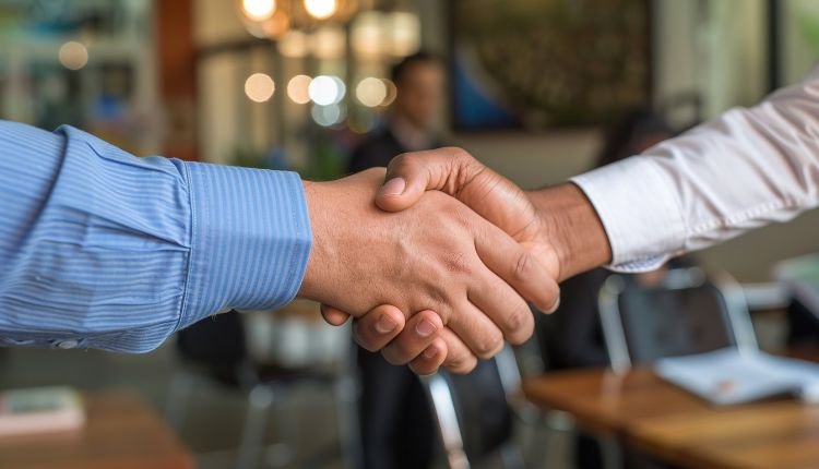 Business handshake in office setting.